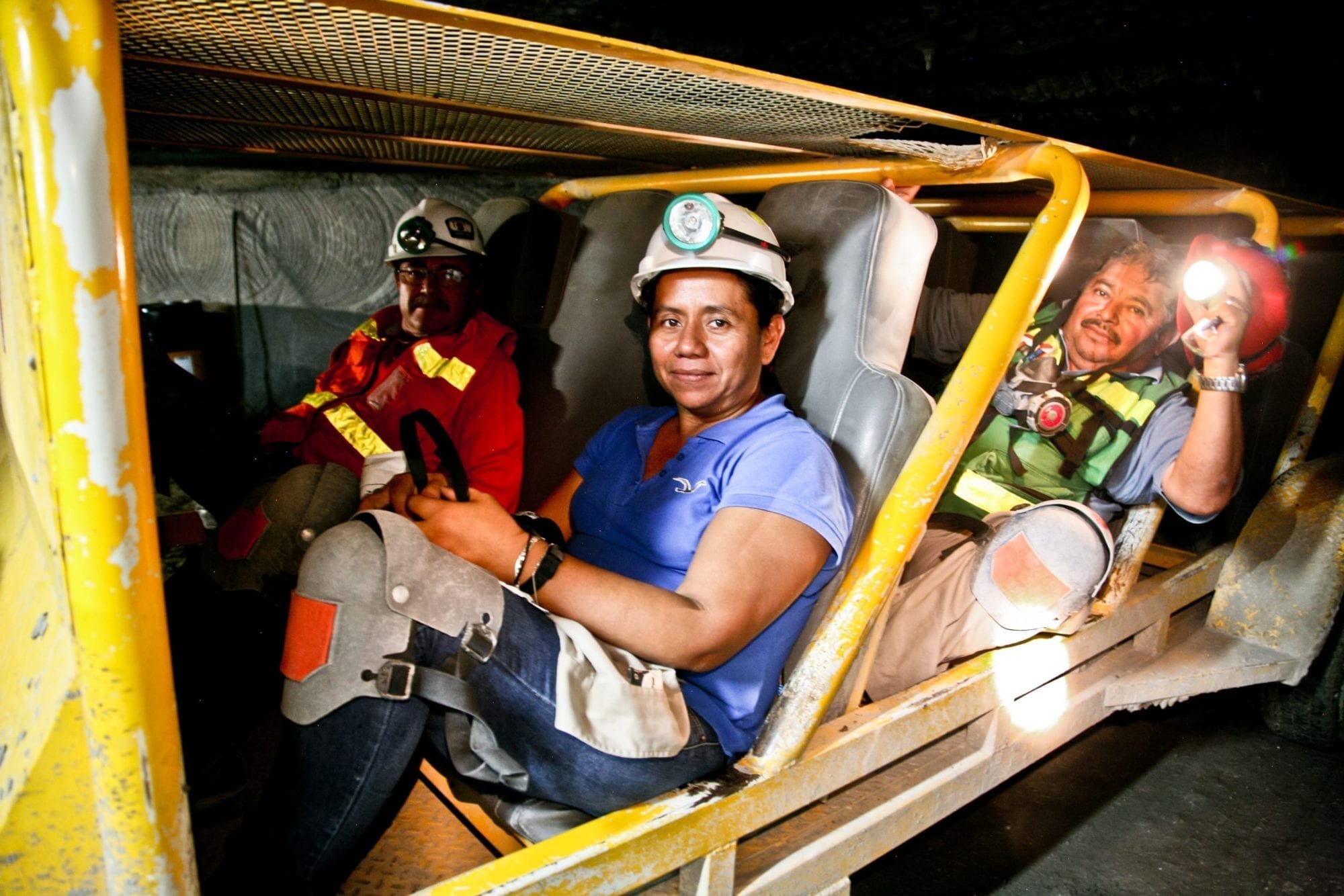 Ruth Rivera and her co-workers travel through the mines in a cart that transports all personnel.